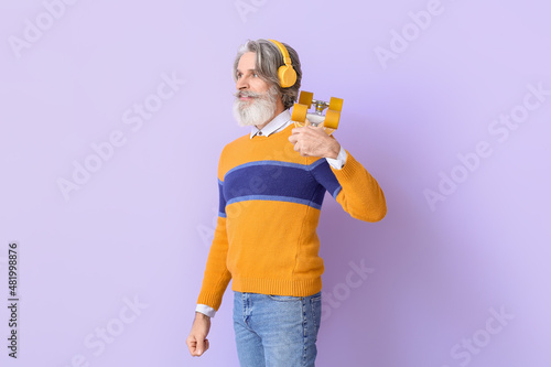 Senior man in headphones wi...