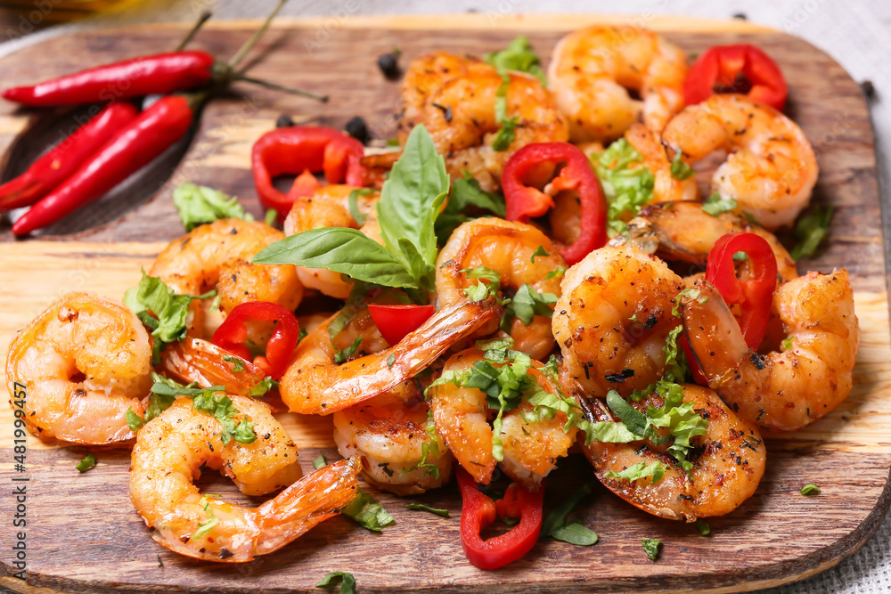 Wooden board of tasty shrimp tails on table Wooden board of tasty shrimp tails on table