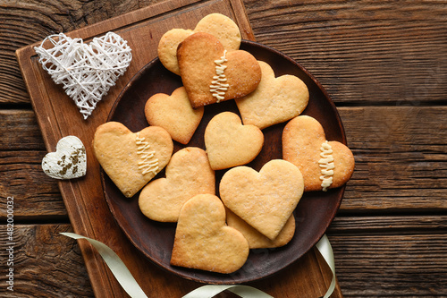 Plate with tasty heart shaped cookies on wooden background. Valentines Day celebration