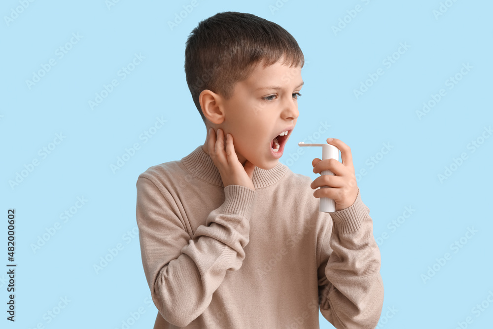 Ill little boy with inhaler on blue background Ill little boy with inhaler on blue background