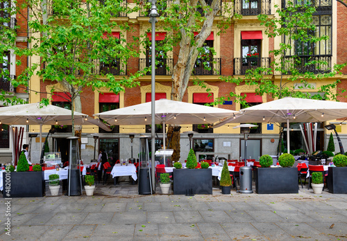 Old street with table of restaurant in Madrid, Spain. Architecture and landmark of Madrid, postcard of Madrid.