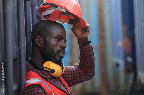 Obraz na płótnie African American handsome black engineer he is working in container box yard area of logistics transportation import export or shipping industry w salonie