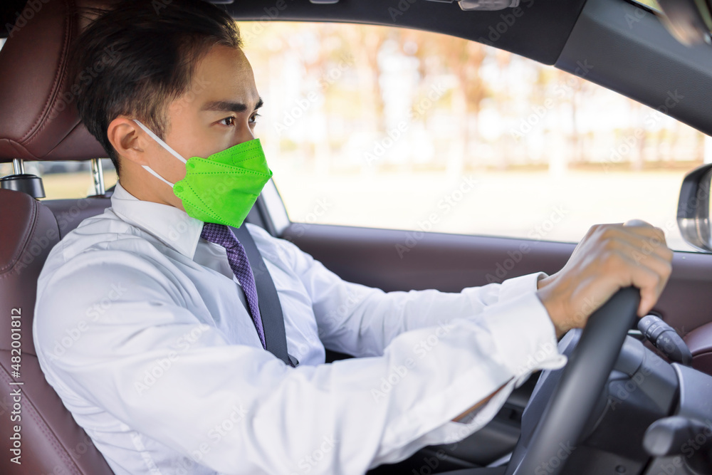 Business man wearing protective  medical mask and driving in the car during coronavirus outbreak