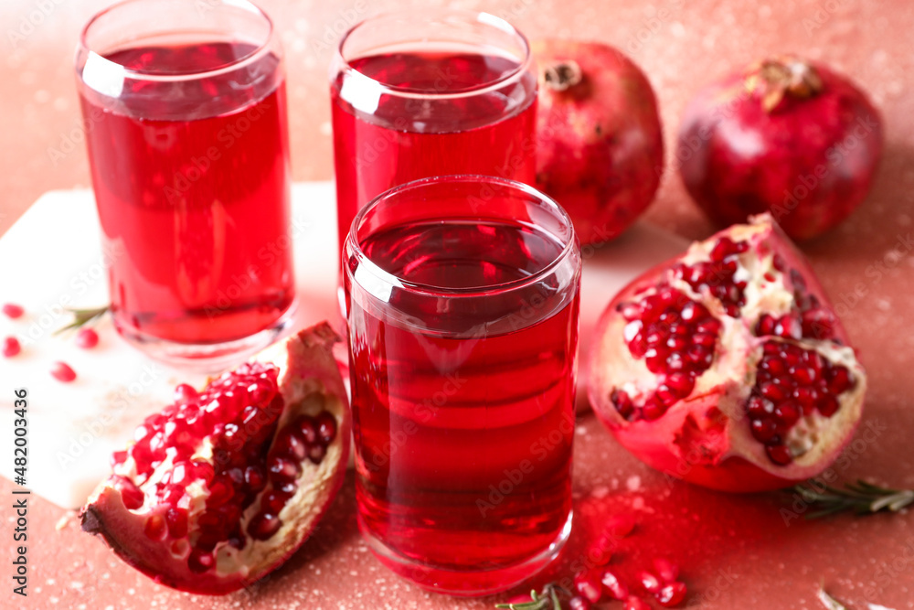 Glasses of delicious pomegranate juice on red background Glasses of delicious pomegranate juice on red background