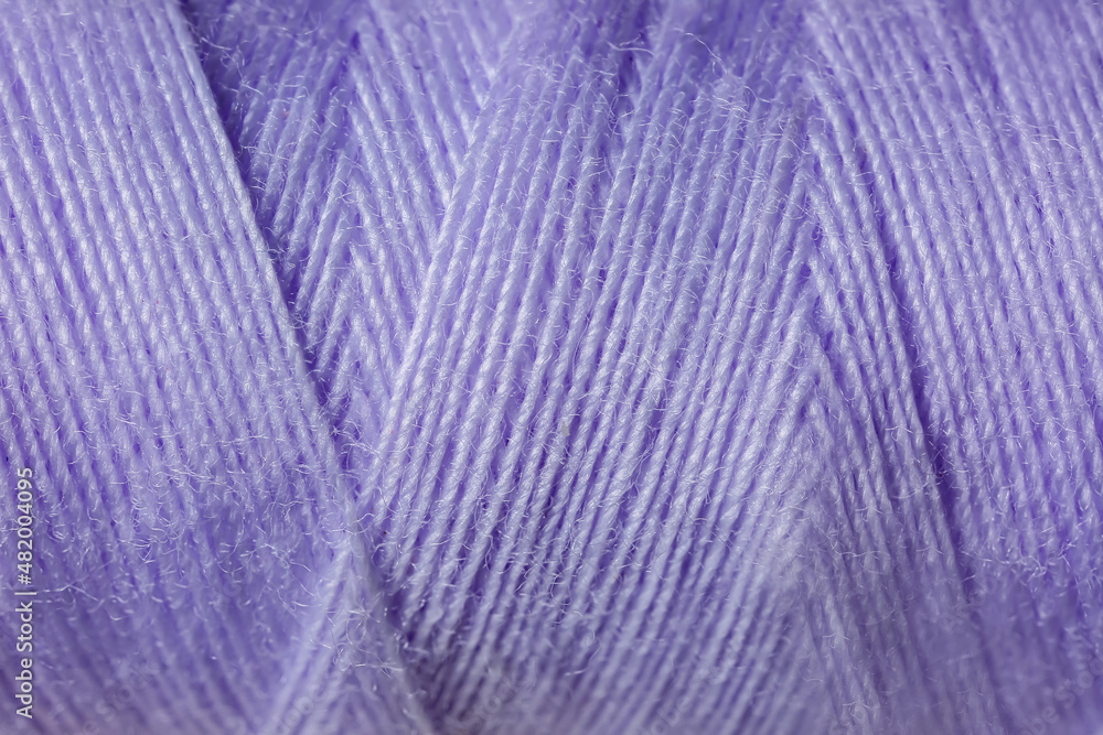 Fototapeta premium Purple sewing thread close-up, textile material for craft and hobby projects