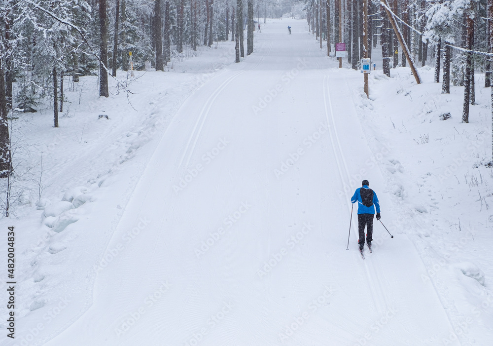 Skier man, athlete, runs on skis on the ski track. Winter sports.