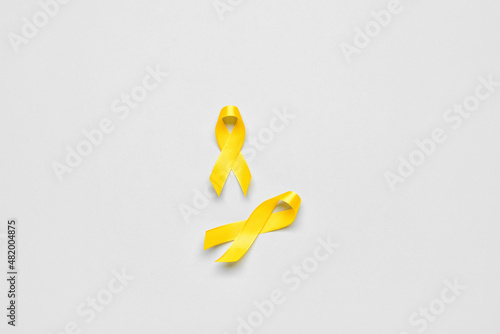 Golden awareness ribbons on light background. International Childhood Cancer Day