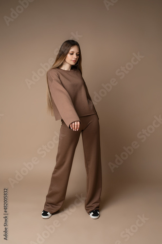 Cool young girl wearing stylish fashion sportswear, sports suit, cap, sunglasses. Sportive female style, unisex outfit