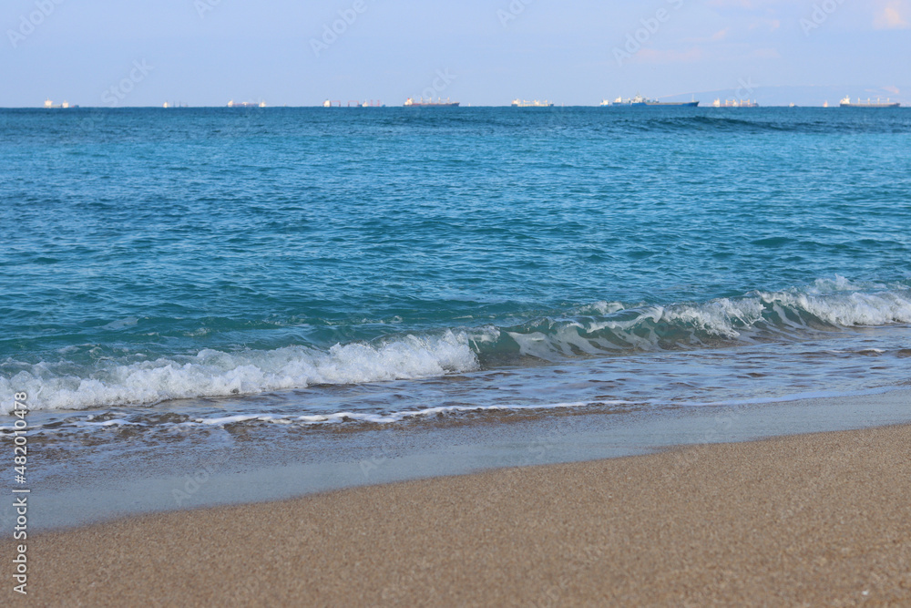 Clear blue sea water close up photo. Calm sea, blue sky,  tranquil scene. Warm day on the beach. 