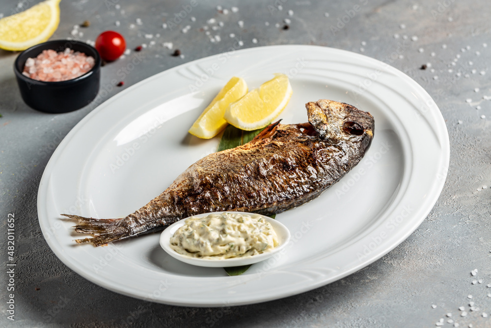 Delicious Grilled dorado fish with lemon and parsley. Whole Bbq sea ...