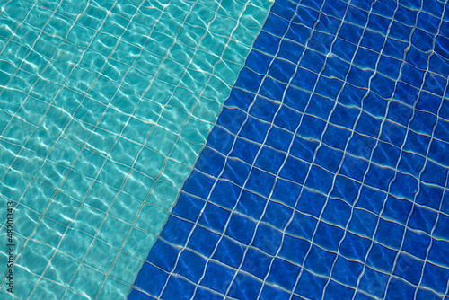 Background of rippled pattern of clean water in a blue swimming pool.