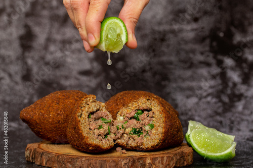The traditional Arabic snack of kibbeh in Brazil called Quibe. Kibe served with lemon photo