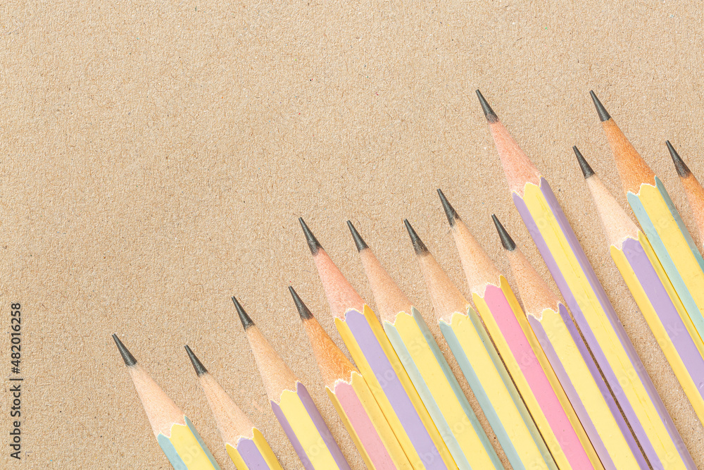 several pencils,pencil on brown background,top view of wooden brown pencil placed on brown paper for background several pencils,pencil on brown background,top view of wooden brown pencil placed on brown paper for background