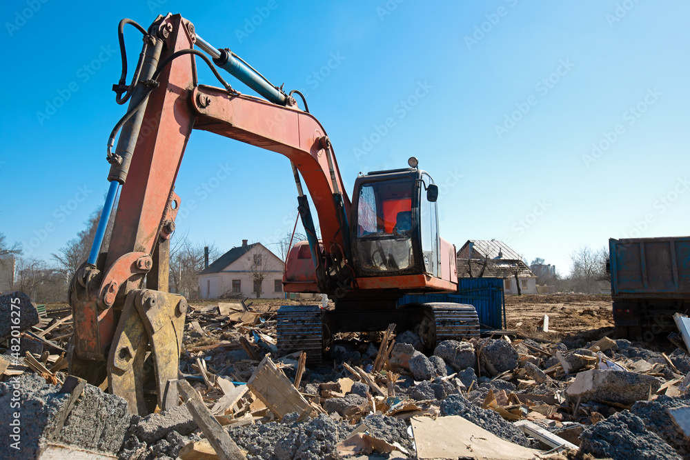 Demolition works. Excavator broken houses at construction site during rebuilding construction jobs Demolition works. Excavator broken houses at construction site during rebuilding construction jobs