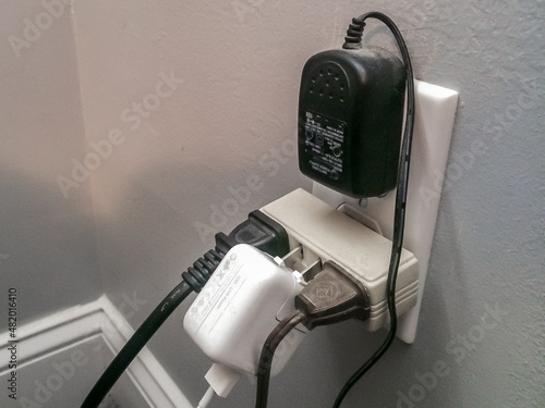 Dangerous overloaded electric outlet with exposed prongs