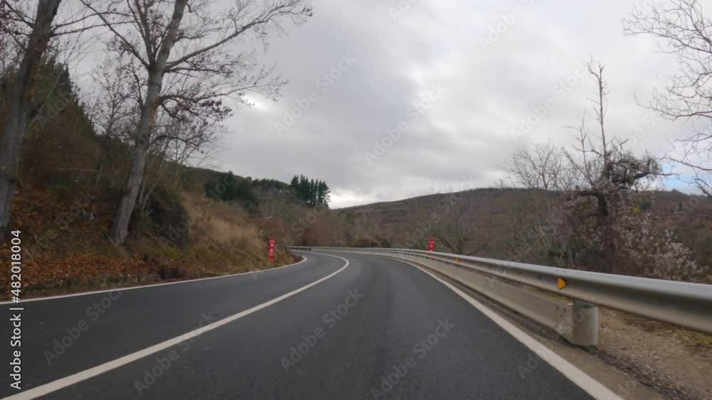 4K video of a subjective camera of a car driving along mountain roads in the El Bierzo region in autumn with wet asphalt, taking dangerous curves and the Cornatel castle in the background 4K video of a subjective camera of a car driving along mountain roads in the El Bierzo region in autumn with wet asphalt, taking dangerous curves and the Cornatel castle in the background