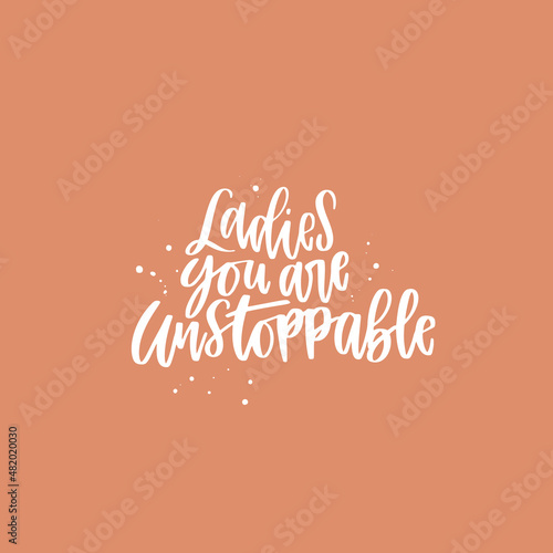 Positive inspirational quote hand drawn color vector lettering Ladies you are unstoppable. Abstract drawing with text isolated on orange background.