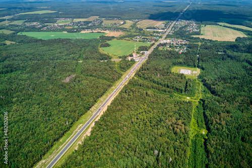 Aerial view from a high altitude of a highway running through a forested area. Varshavskoye highway in Zhukovsky district, Kaluga region, Russia photo