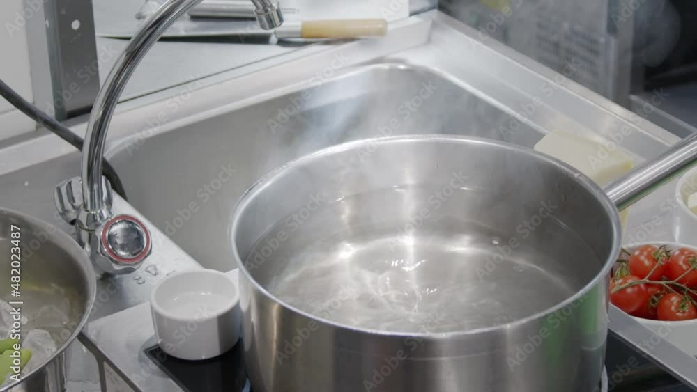 Poached egg, the cook breaks the egg into a pot of hot water.
Cooking in the kitchen. Poached egg, the cook breaks the egg into a pot of hot water.
Cooking in the kitchen.