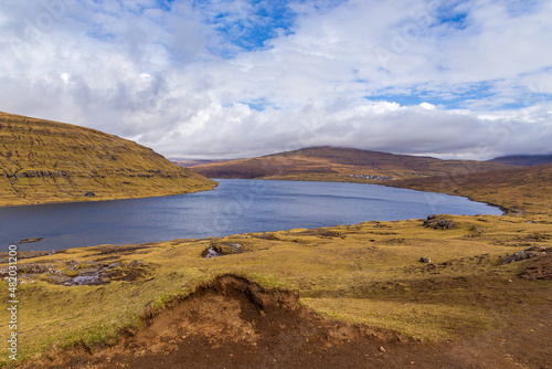 Woman on a bench looking at Leitisvatn Lake  Faroe Islands.