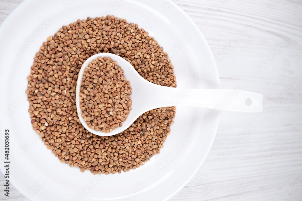 buckwheat in a white bowl with a spoon on the table buckwheat in a white bowl with a spoon on the table