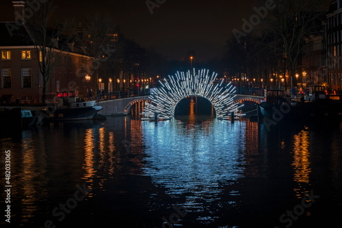 Illuminated bridge in Amsterdam at the Amstel in the Netherlands at night