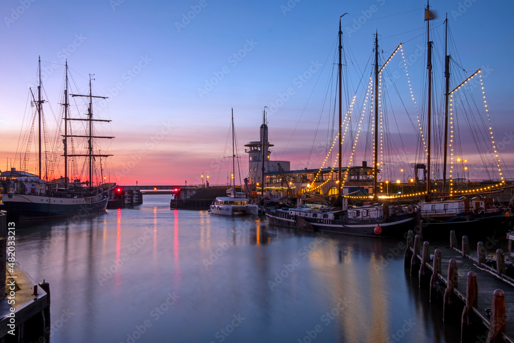 Harbor from Harlingen with decorated sailing boats in Friesland the Netherlands at sunset