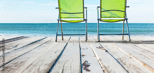 Liegestühle auf einer Terrasse aus Holz am Meer photo