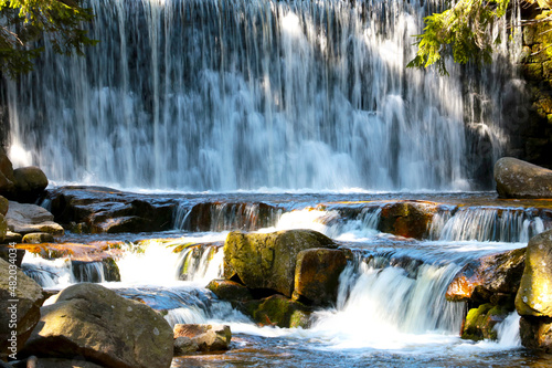 Beautiful picturesque waterfall in the forest in the highlands.
