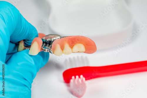 Partial denture and toothbrush. Denture cleaning, oral health, dental exam and teeth cleaning concept