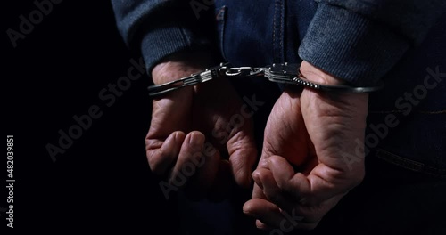 arrested man with cuffed hands behind back