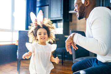 authentic ethnic multicultural people wearing bunny ears in living room day sunlight