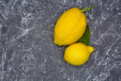 Zitrone mit Blatt auf einen grauenMarmor Hitnergrund
