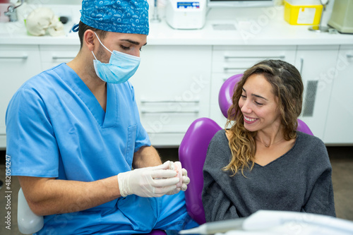 Dentist showing a procedure to a young female patient