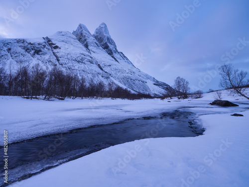 Fototapeta Naklejka Na Ścianę i Meble -  Frozen river and mountain. A classic view in Norway during winter. Otertind mountain, Norway. Landscape during sunset.