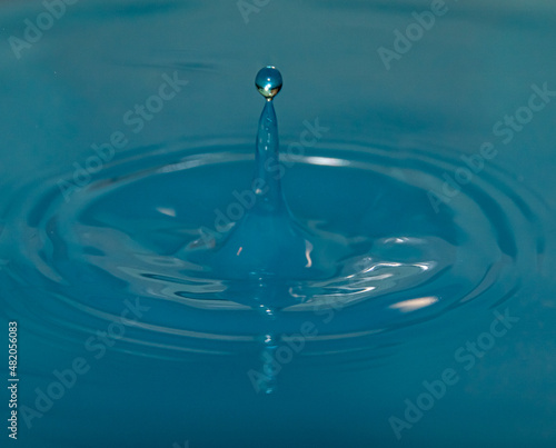 water droplet falls into water with ripples