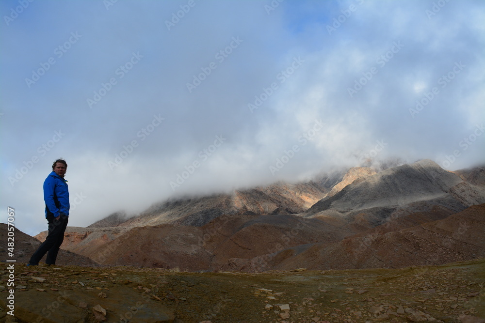 one person standing on a hill, blue sky and clouds on a sunny day in December in Death Valley National Park
