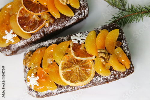 Traditional Christmas stollen on white background. Dessert is decorated with dried fruits and candied fruits.