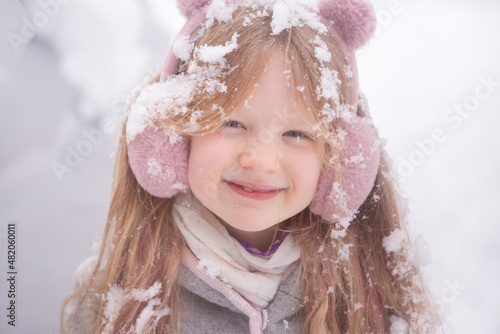 маленькая девочка в снегу дёргает за вестку падают снежинки на лице и волосах
a little girl in the snow pulls the rope snowflakes fall on her face and hair