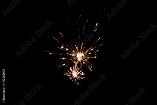 Fireworks in the night sky. Texture of colored lights background. Festive salute lights attract. Large festive firework on a black background