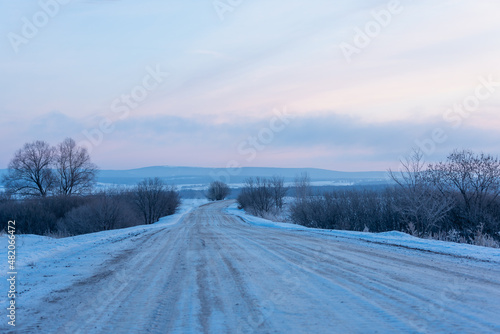 Snowy road outside the city at dawn.