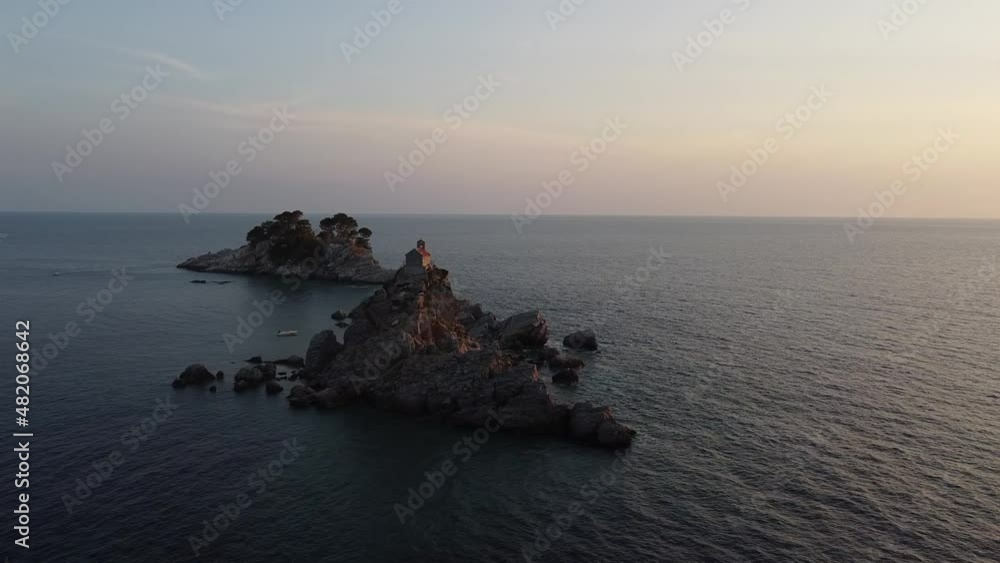 Drone aerial view of Christian Church of Holy Sunday on small island Katic in Petrovac, Montenegro during summer sunset. Epic religious and tourist attraction accessible by boat. Drone aerial view of Christian Church of Holy Sunday on small island Katic in Petrovac, Montenegro during summer sunset. Epic religious and tourist attraction accessible by boat.