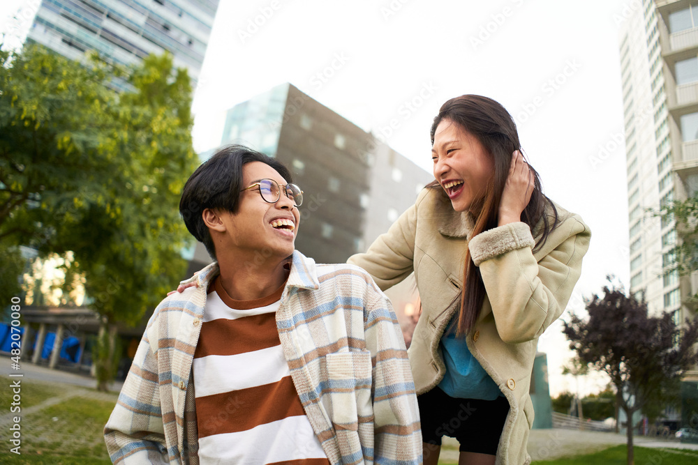 Happy smiling asian couple having fun and looking at each other. Young lovers making holidays. Youth culture and city lifestyle. Happy smiling asian couple having fun and looking at each other. Young lovers making holidays. Youth culture and city lifestyle.