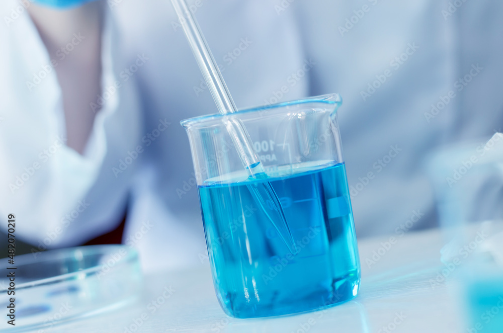 The scientist conducts research in the laboratory. Clinical trials and vaccine development. Hands of a scientist with a laboratory pipette The scientist conducts research in the laboratory. Clinical trials and vaccine development. Hands of a scientist with a laboratory pipette