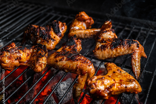 Chicken wings on barbecue, outdoor BBQ grill with fire. Top view