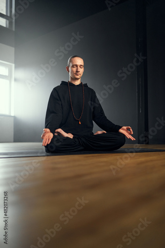 The yogi man meditate in the lotus position with gyan mudra. Yoga practice in the studio.