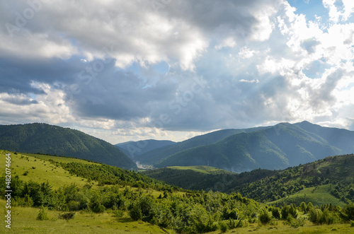 River flowing through mountain valley covered with dense forests under cloudy sky. Carpathian mountains, Ukraine