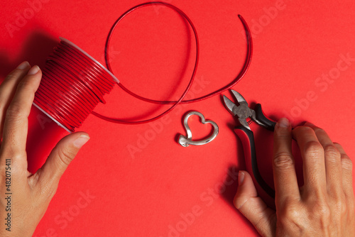 craftswoman creating heart-shaped pendant with leather and zamak metal