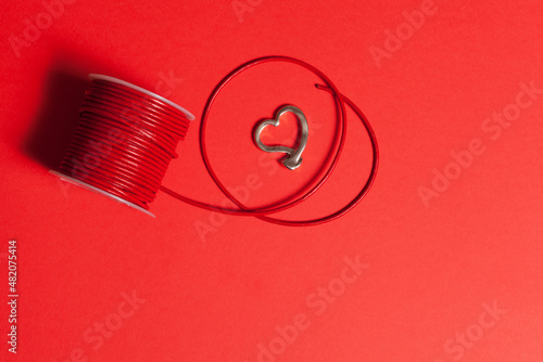 materials to make a heart pendant with a red background. leather cord and metallic heart photo