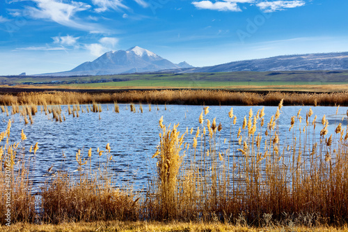 Nameless lake on the background of blue sky and mountains of Caucasian Mineral waters. The Bull and Beshtau mountains, the laccoliths of the North Caucasus. Winter landscape